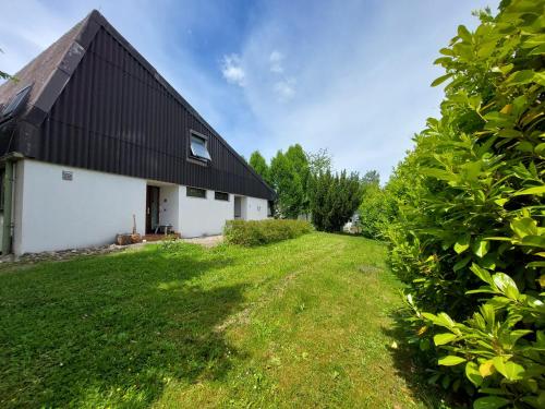 a house with a black roof and a green yard at Pension beim Kastell in Sulz am Neckar