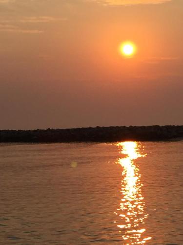 a sunset over the water with the sun setting at Villa Viola in Torre Chianca