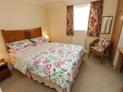 a bedroom with a bed and a chair and a window at Westmount in Ryde
