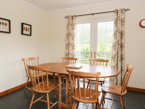 a dining room with a wooden table and chairs at Brae Mhor Cottage in Fort William