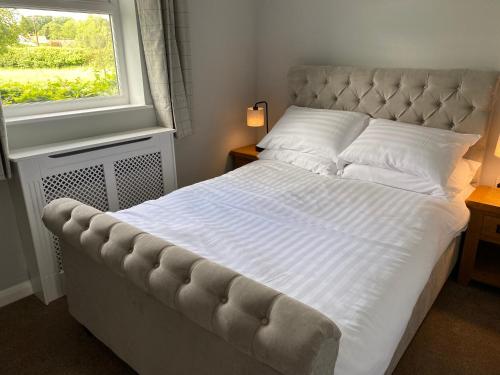 A bed or beds in a room at Beck Hill Cottage In Brandsby