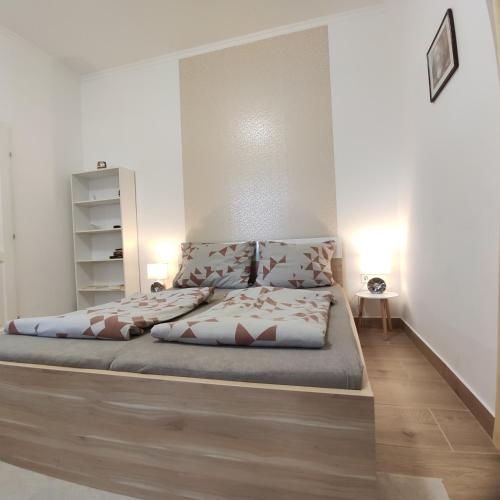 a bed in a bedroom with two pillows on it at Fabi Apart in Hévíz