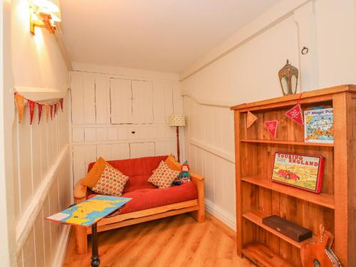 a living room with a red couch and a table at The Stables in Millom