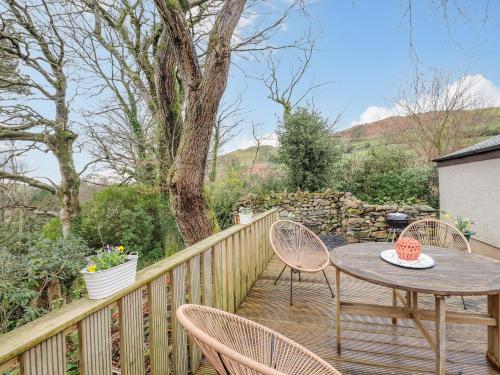 a wooden deck with a table and chairs at The Stables in Millom