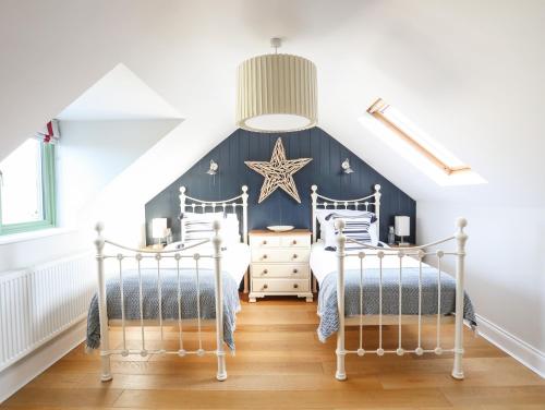 two beds in a attic bedroom with a star on the wall at Dolwaenydd in Llanfairpwllgwyngyll