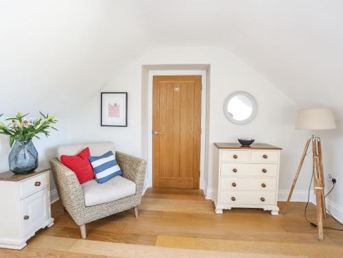 a living room with a chair and a wooden door at Dolwaenydd in Llanfairpwllgwyngyll