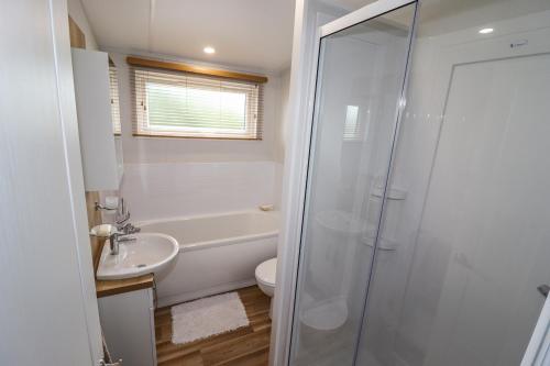 a bathroom with a shower and a toilet and a sink at Bramblewick in Runswick