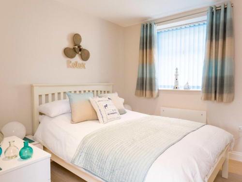 a bedroom with a white bed and a window at Egret in Brixham