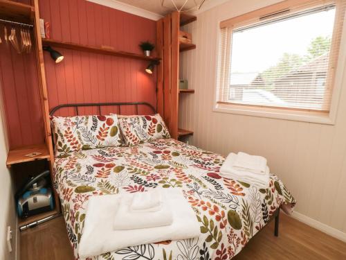 a bedroom with a bed with a comforter and a window at 3 Valley View Lodges in York