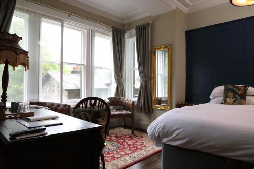 a bedroom with a bed and a desk and a window at Pont y Pair Inn in Betws-y-coed