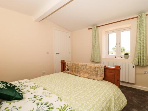 a bedroom with a bed and a window at The Old Cow Shed in Banwell