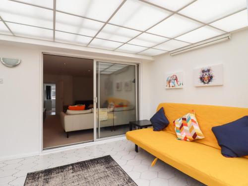 a living room with a yellow couch and a living room at 35 Seabourne Way in Dymchurch