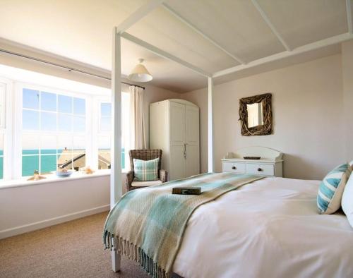 a bedroom with a large bed and a large window at Castaway in Port Isaac
