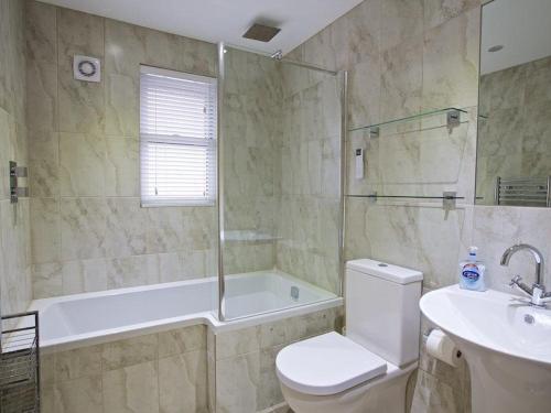 a bathroom with a tub and a toilet and a sink at Crowthers in Dartmouth