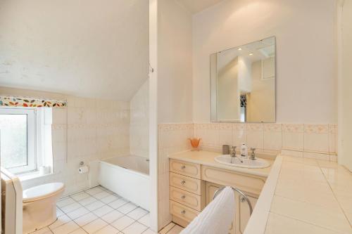 a bathroom with a sink and a tub and a toilet at Dales Croft Apartment in Buxton