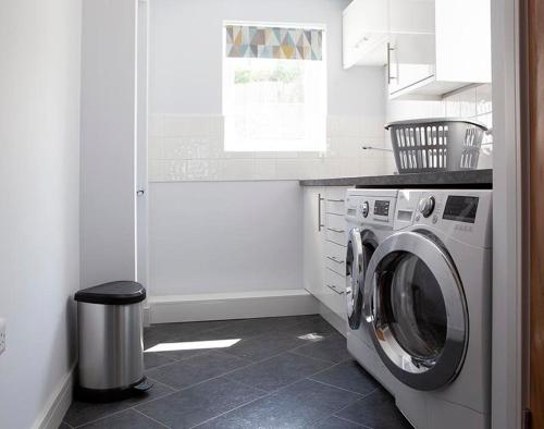 a kitchen with a washing machine and a window at The Crows Nest in Port Isaac