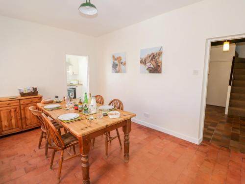 a dining room with a wooden table and chairs at Manor Farm Cottage in Worcester