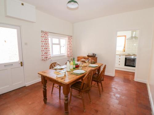 a dining room with a wooden table and chairs at Manor Farm Cottage in Worcester