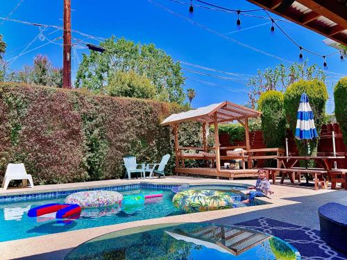 a swimming pool with a child playing in it at Endless summer in LA *HEATED POOL/HOT TUB/CABANA* in Los Angeles