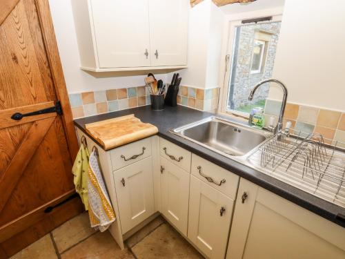 uma cozinha com um lavatório e uma bancada em The Annexe em Keighley