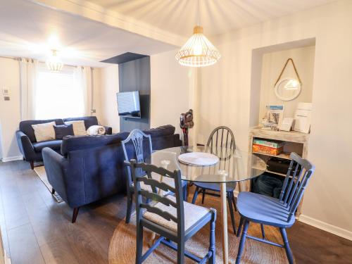 a living room with a table and chairs and a couch at Driftwood Terrace in Porthmadog
