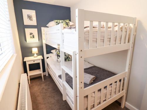 a bunk bed room with two bunk beds at Driftwood Terrace in Porthmadog