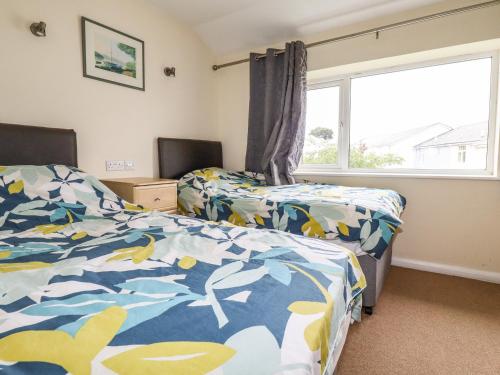 a bedroom with two beds and a window at 87 Atlantic Reach in Newquay