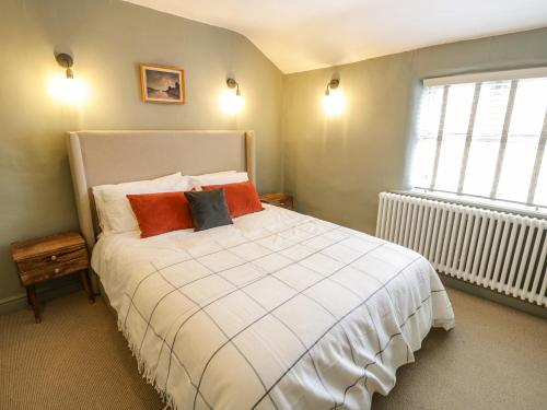 a bedroom with a white bed with pillows and a window at 5 Bull Street in Stratford-upon-Avon