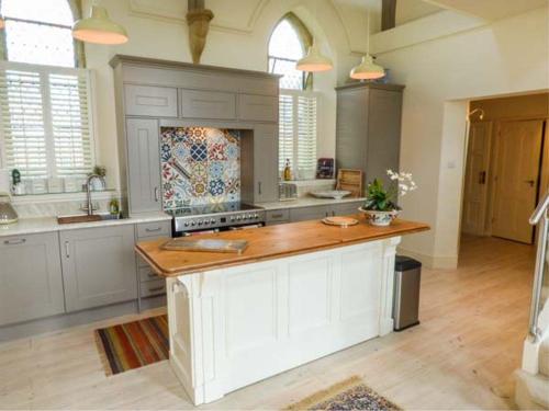 uma grande cozinha com armários brancos e um balcão de madeira em Chapel House em Ventnor
