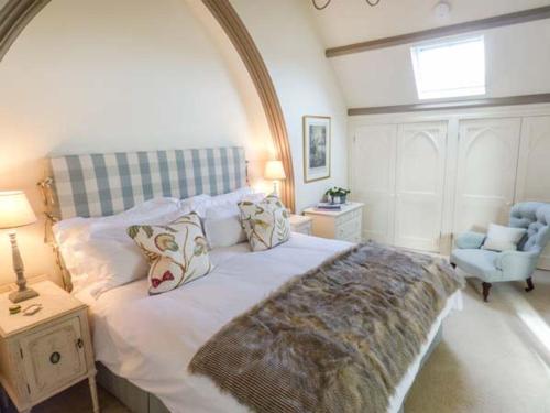 a bedroom with a large bed and a chair at Chapel House in Ventnor