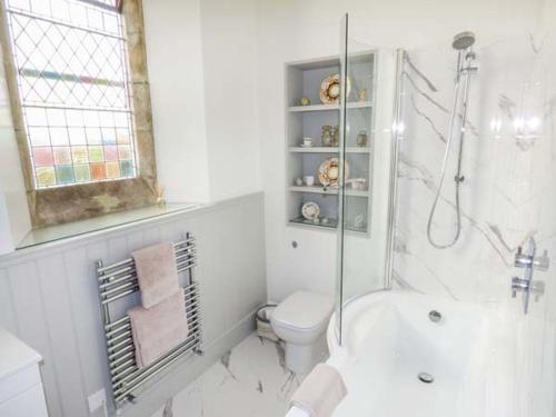 a white bathroom with a tub and a toilet at Chapel House in Ventnor
