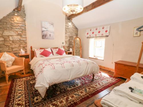 Un dormitorio con una cama y una pared de piedra. en The Priory, en Bakewell