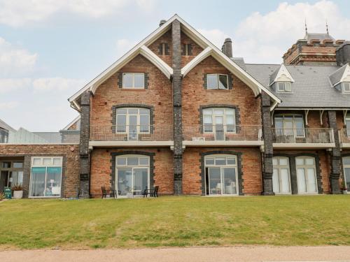 a large brick house with a large yard at 21 The Rest in Porthcawl