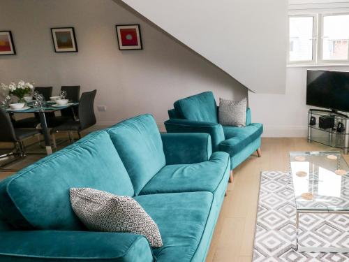 a living room with a blue couch and a table at 21 The Rest in Porthcawl