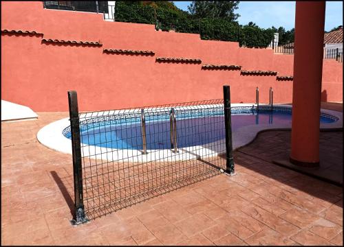 uma cerca em frente a uma piscina em Agradable chalet con piscina en Sierra d'Espadan em Tales
