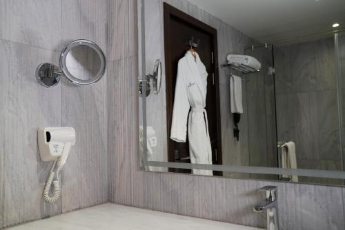 a mirror in a bathroom with a robe on a mannequin at Indigo Heights Hotel & Suites in Lahore