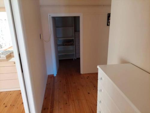 an empty room with a kitchen with a wooden floor at Anna's House in Anavissos