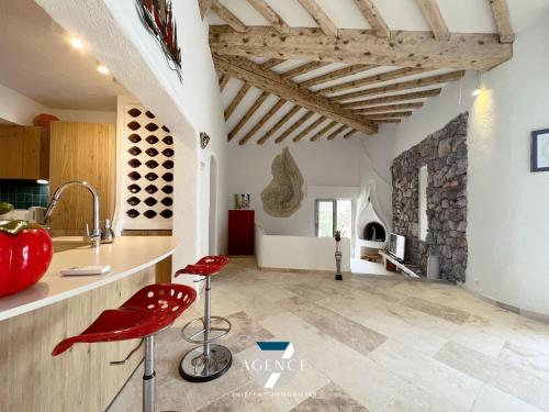 a kitchen with red stools in the middle of a room at Villa IBIZA in Les Issambres