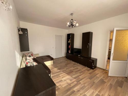 sala de estar con suelo de madera y lámpara de araña en Apartament de lux, en Costinesti