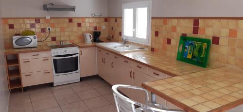 a small kitchen with a stove and a sink at Le Casot in Torreilles