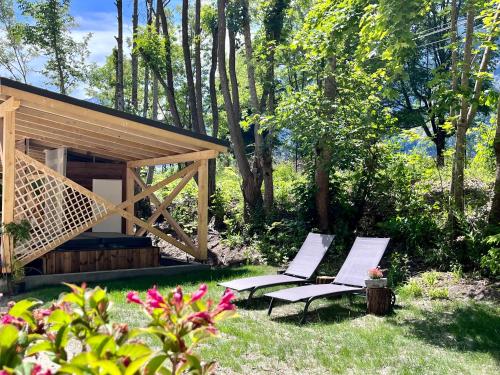 zwei Stühle in einem Garten neben einer Hütte in der Unterkunft BO LODGE in Le Bourg-dʼOisans