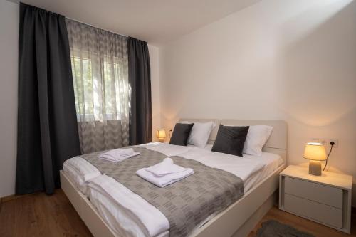 a bedroom with a large bed with two towels on it at Olive & Almond Apartment in Bol