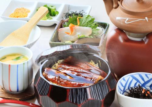 a table with bowls of food and a tea pot at Katsuura Hilltop Hotel & Residence in Katsuura