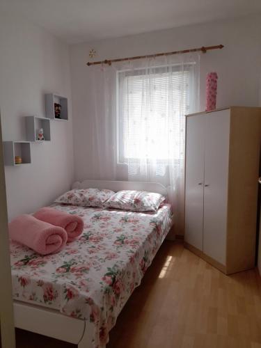 a bedroom with a bed and a dresser and a window at Apartmani Pleša in Vir