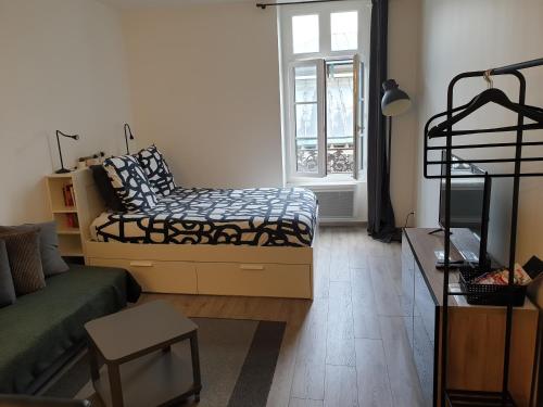 a living room with a bed and a window at Au 16 in Dijon