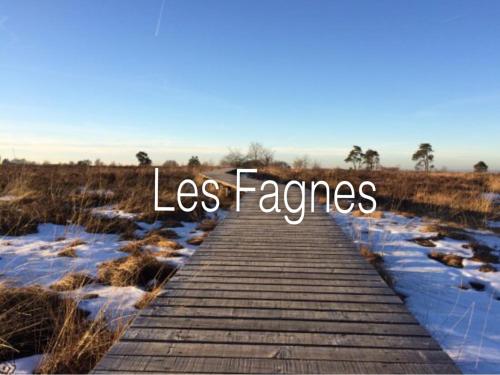 a wooden boardwalk in a field with the words less fences at La Ferme du Soyeuru in Spa