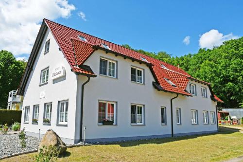 a white house with a red roof at Selliner Pension am Waldrand in Ostseebad Sellin