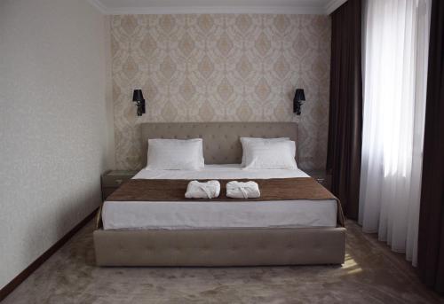 a bedroom with a bed with two towels on it at MirOtel Hotel in Astana