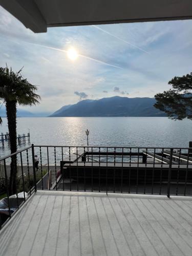 a view of a large body of water with the sun at Brissago Lake Apartment in Brissago