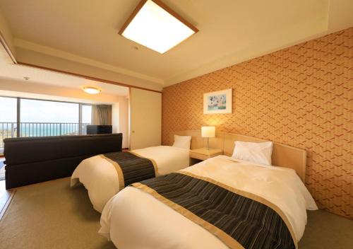 a hotel room with two beds and a window at Katsuura Hilltop Hotel & Residence in Katsuura